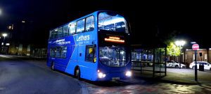 Lethers Travel double decker lit up at night at Leeds city centre bus stop